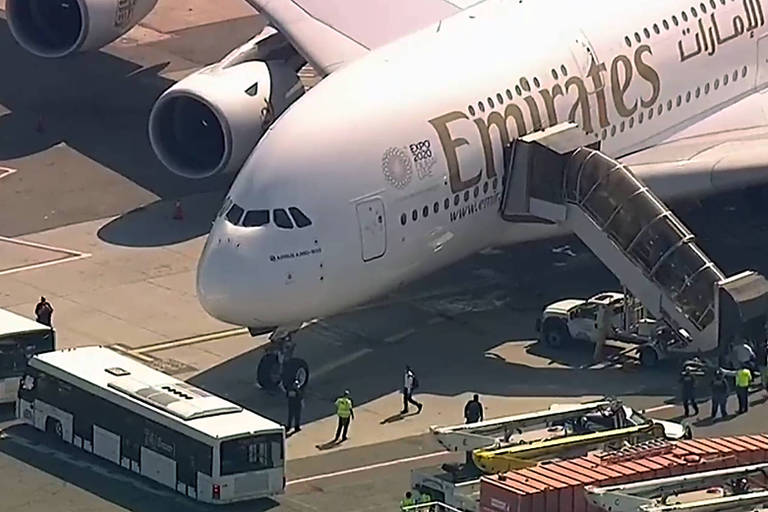 Pessoas deixam Airbus A380 da Emirates no aeroporto JFK, em Nova York; avião foi isolado após passageiros adoecerem a bordo