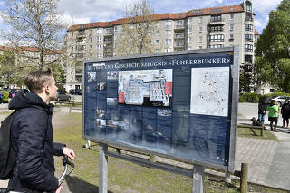Tourist reads an information billboard giving details about Adolf Hitler's