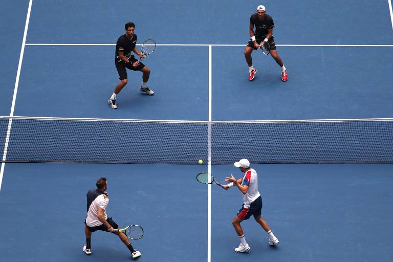 O brasileiro Marcelo Melo e o polonês Lukasz Kubot (uniforme preto) em ação contra os americanos Jack Sock e Mike Bryam, na final do Aberto de tênis dos Estados Unidos