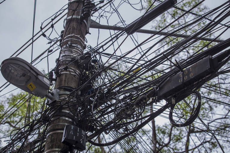 Poste com emaranhado de fios na Lapa, zona oeste; concessionária mira 2.100 postes