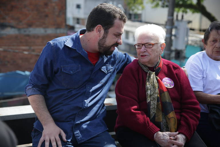 O candidato à Presidência Guilherme Boulos (PSOL) conversa com a deputada federal Luiza Erundina durante agenda de campanha na comunidade de Heliópolis, zona sul da capital paulista