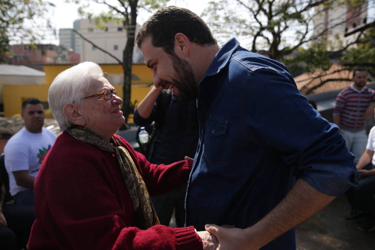 O candidato à Presidência Guilherme Boulos (PSOL) conversa com a deputada federal Luiza Erundina durante agenda de campanha na comunidade de Heliópolis, zona sul da capital paulista