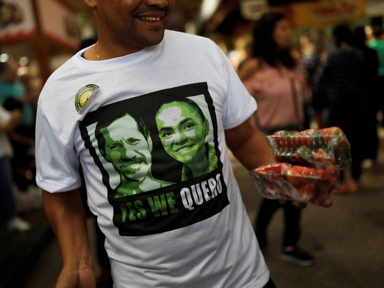 Apoiador veste camiseta com as imagens dos candidatos da Rede, à Presidência da República Marina Silva e seu vice Eduardo Jorge, após um comício em São Paulo