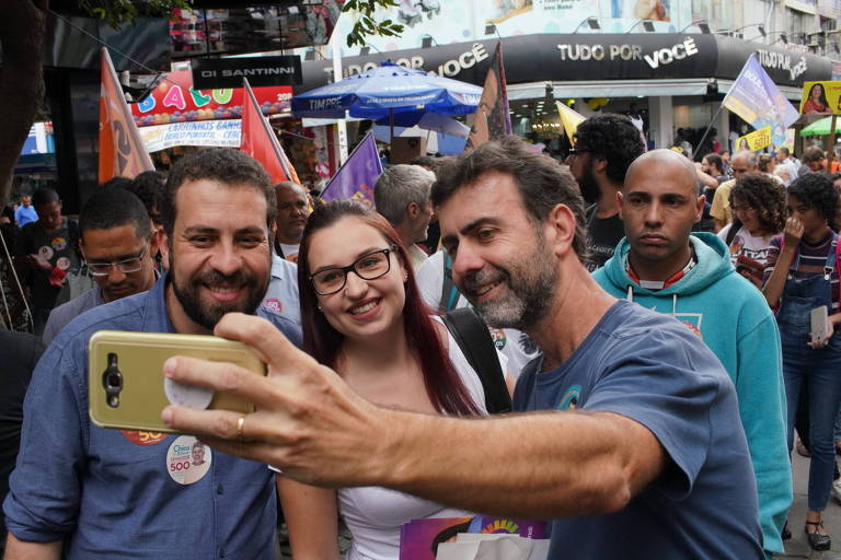 Guilherme Boulos (PSOL) tira selfie com eleitora e o candidato à deputado federal Marcelo Freixo (PSOL) em Nilópolis na baixada Fluminense, Rio de Janeiro 