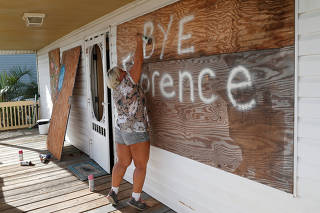 Lisa Evers of Oak Island decorates her storm shutters before evacuating her house ahead of the arrival of Hurricane Florence in Oak Island