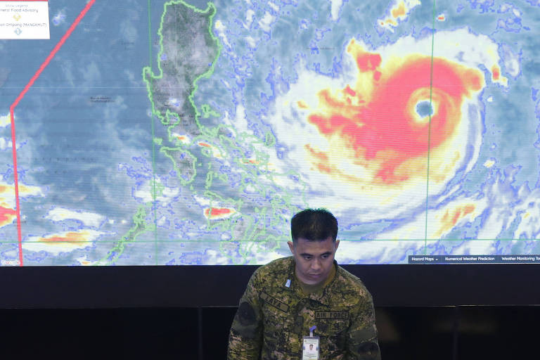 Membro da Força Aérea filipina em frente a uma imagem de satélite do tufão Mangkhut, no centro de operações do Conselho Nacional de Redução dos Riscos de Desastres, em Manila