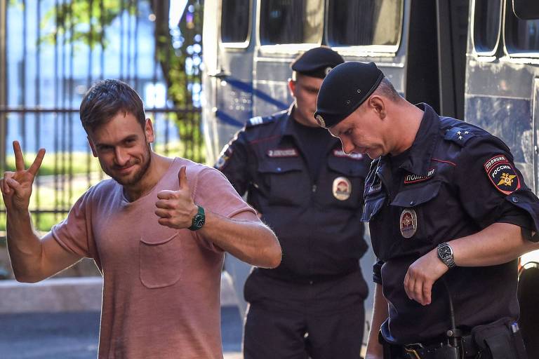 Pyotr Verzilov (esq.), ativista do Pussy Riot, é levado para audiência judicial em Moscou