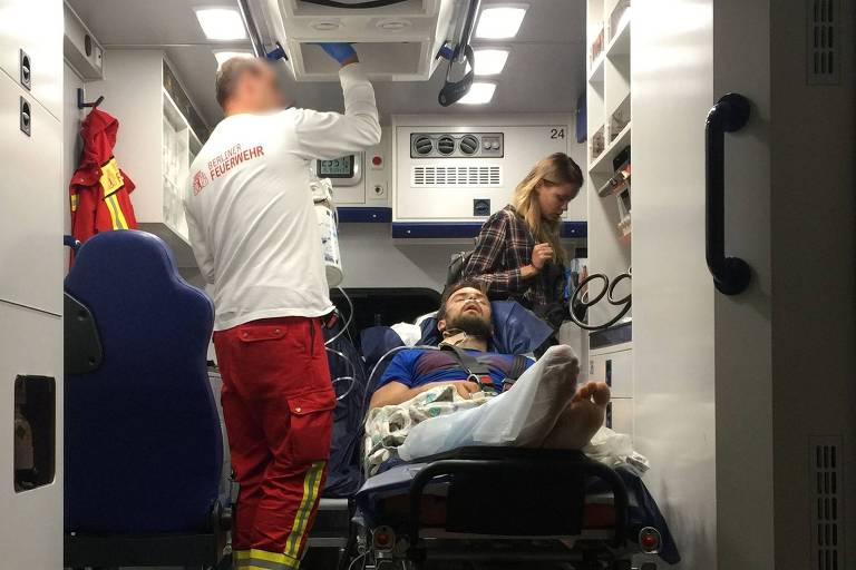 A ativista russo Piotr Verzilov é conduzido em ambulância após a chegada em Berlim

