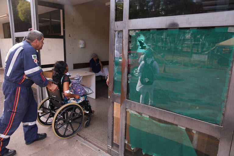 Mulher em cadeira de rodas é empurrada por paramédico 