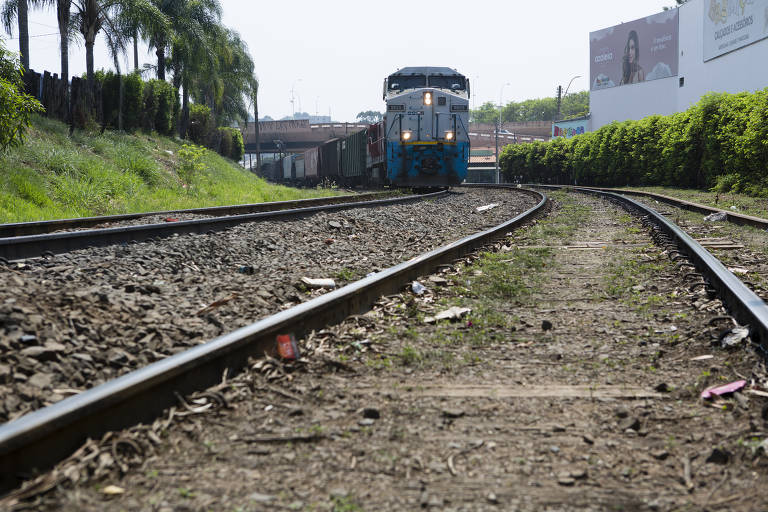 Imagem mostra trem sobre trilhos em uma cidade do interior
