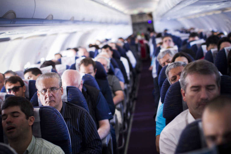 Passageiros sentados dentro de avião