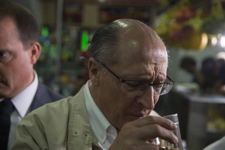 Alckmin segura um copo de café durante campanha no Brás, em São Paulo, nesta terça