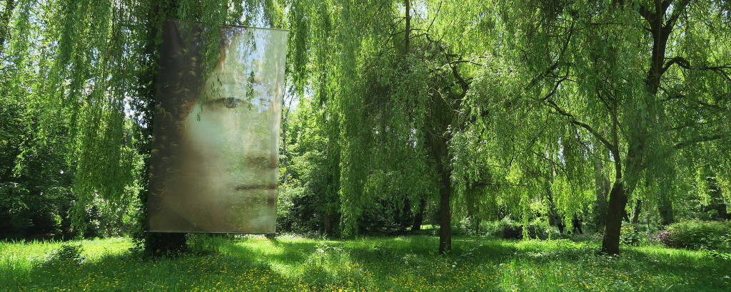 Quadro de Leonardo da Vinci reproduzido em tela translúcida no meio da vegetação dos jardins do castelo Clos Lucé, em Amboise