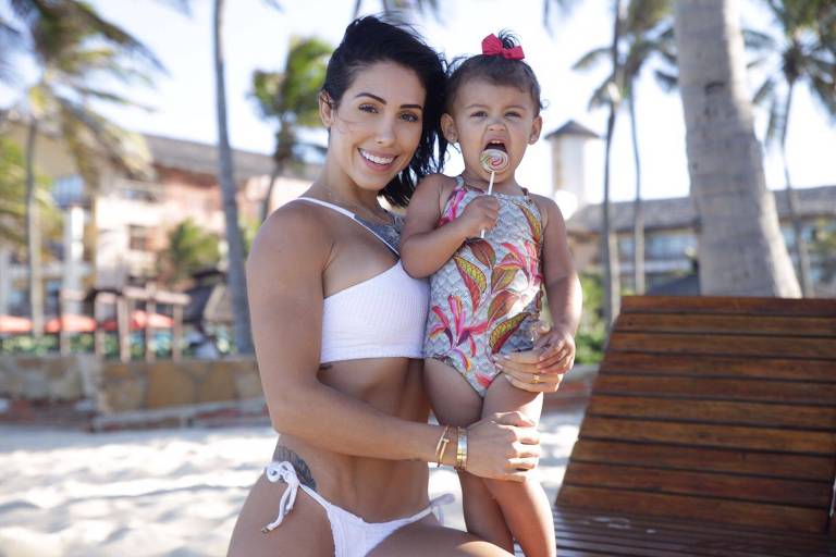 Bella Falconi e a sua filha Victoria, 3 anos, em passeio na praia