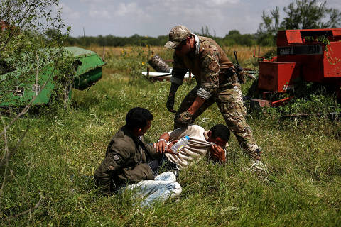 A border patrol agent apprehends men from Brazil after they illegally crossed into the U.S. border from Mexico in Los Ebanos, Texas, U.S., August 15, 2018.  REUTERS/Adrees Latif      TPX IMAGES OF THE DAY ORG XMIT: FFF-AAL106