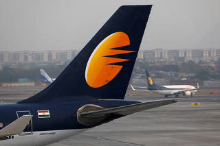 FILE PHOTO: A Jet Airways plane is parked as other moves to runway at the Chhatrapati Shivaji International airport in Mumbai