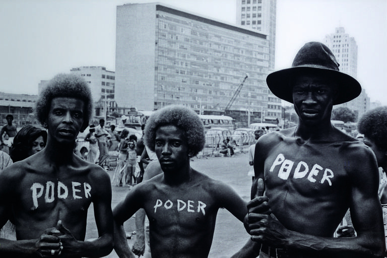 homens negros com "poder" escrito no peito em tinta branca
