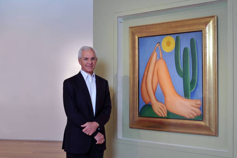 O empresário Eduardo Costantini posa ao lado do quadro 'Abaporu', de Tarsila do Amaral