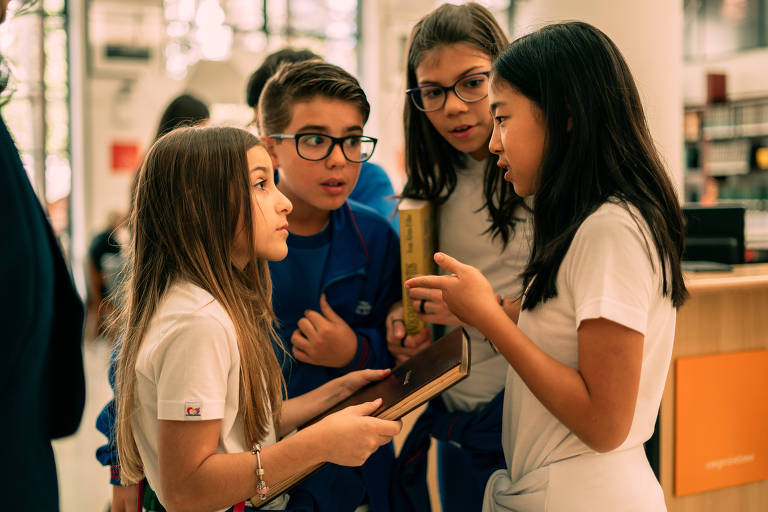 Crianças debatem a melhor forma de encontrar o nome do primeiro presidente; depois de um debate, decidem procurar no índice