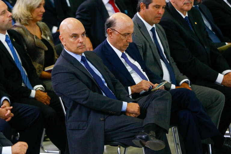 O então ministro da Justiça, Alexandre de Moraes, ao lado do ministro do ex-ministro da Fazenda, Henrique Meirelles, no evento de anúncio de novas medidas para o programa Minha Casa Minha Vida, no Palácio do Planalto em Brasília