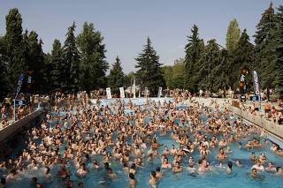 People are seen in a pool at the Palatinus outdoor spa in Budapest