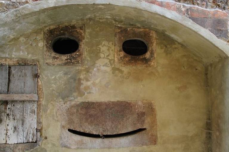 Uma parede na Toscana, Itália, remete a um rosto sorridente