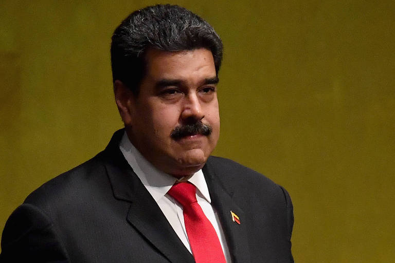 Com terno preto, camisa branca e gravata vermelha, Maduro aparece à frente de fundo amarelo. Em sua lapela esquerda há um broche com o formato da bandeira venezuelana.