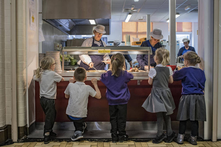 Students line up for their lunch at Morecambe Bay Primary School, in Morecambe, England, May 2, 2018. Changes to welfare benefits and funding cuts are driving the working poor into crisis ? and reversing a long-term decline in the childhood poverty rate. (Laura Boushnak/The New York Times)