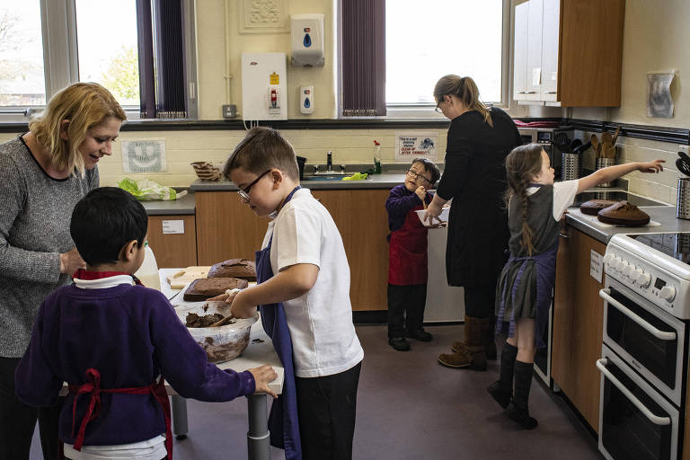 Students decorate a cake in the kitchen lab at Morecambe Bay Primary School, in Morecambe, England, May 2, 2018. Changes to welfare benefits and funding cuts are driving the working poor into crisis ? and reversing a long-term decline in the childhood poverty rate. (Laura Boushnak/The New York Times)