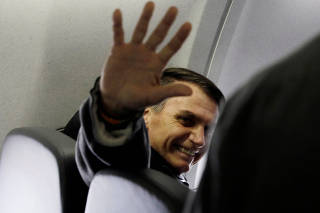 Presidential candidate Jair Bolsonaro waves on board his flight from Sao Paulo to Rio de Janeiro