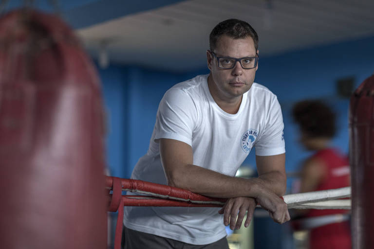 O boxeador e antropólogo Luke Dowdney, 45, posa em pé, no ringue da academia de artes marciais no Complexo da Maré, no Rio