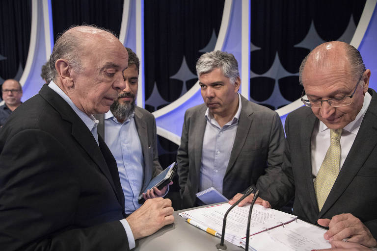 O candidato Geraldo Alckmin (PSDB) recebe orientações de assessores e José Serra (esq) durante intervalo do debate promovido pela Folha, UOL e SBT, com mediação do jornalista Carlos Nascimento, no estúdio do SBT em São Paulo