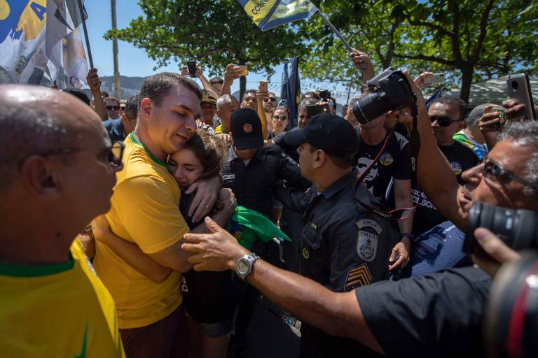 O candidato ao Senado Flavio Bolsonaro (PSL) cumprimenta eleitora durante comício na praia de Copacabana no Rio de Janeiro; militantes demonstraram apoio ao seu pai, o candidato à Presidência Jair Bolosonaro (PSL) que está convalescendo após ser esfaqueado durante agenda de rua em Juiz de Fora