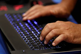FILE PHOTO: A man types into a keyboard during the Def Con hacker convention in Las Vegas