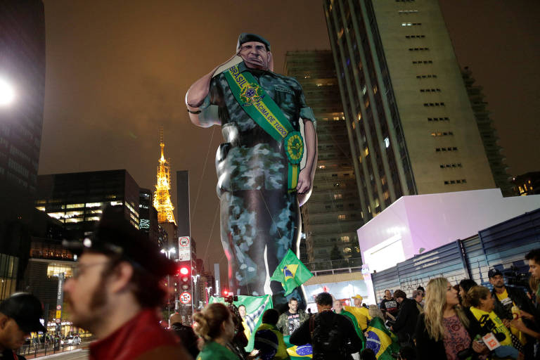 Supporters of Bolsonaro, far-right lawmaker and presidential candidate of the Social Liberal Party (PSL), stand near a giant doll depicting Bolsonaro's candidate for vice president Mourao, in Sao Paulo