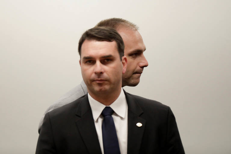 Os irmãos Flávio Bolsonaro (frente) e Eduardo Bolsonaro durante a cerimônia de filiação do pai, Jair Bolsonaro, ao PSL