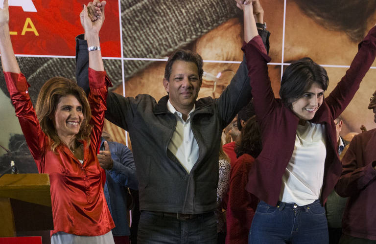 Fernando Haddad (PT) entre sua mulher, Ana Estela, e Manuela D'Ávila (PC do B), sua vice, após votação do primeiro turno