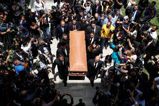 People carry the coffin of the opposition lawmaker Fernando Alban during a ceremony at the National Assembly in Caracas