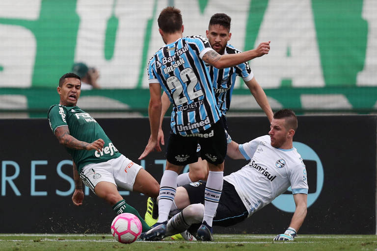 Dudu disputa bola na área com a zaga do Grêmio durante vitória palmeirense no Pacaembu