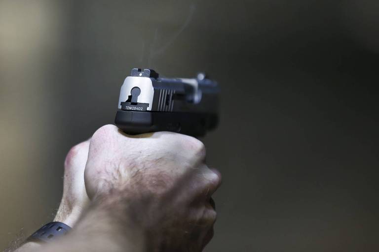 Homem empunha uma pistola Taurus Millenium, de 9mm