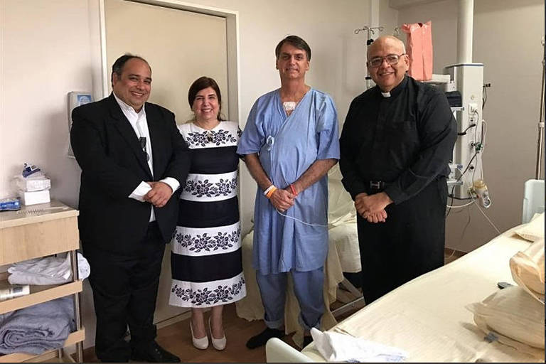 Jair Bolsonaro recebe a visita do Padre Jorjão (à dir.) e padre Omar no hospital