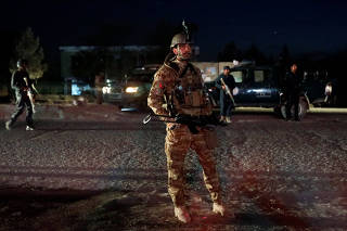 Afghan security forces keep watch at the site of a suicide attack in Kabul, Afghanistan