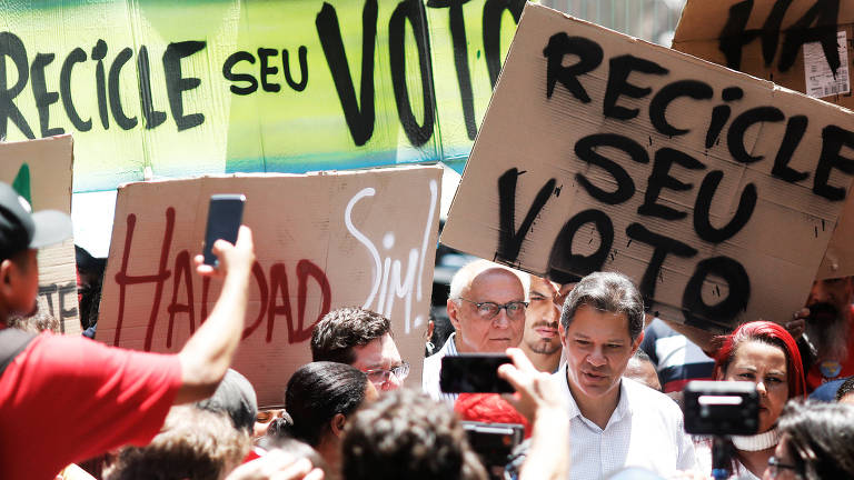 Fernando Haddad (PT) é recebido por apoiadores na chegada à cooperativa de reciclagem, no bairro de Pinheiros em São Paulo