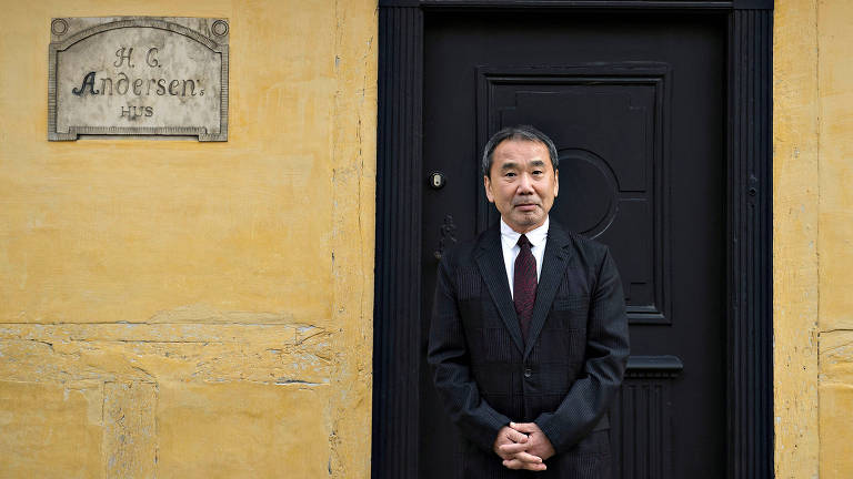 O escritor Haruki Murakami em frente à porta de uma casa