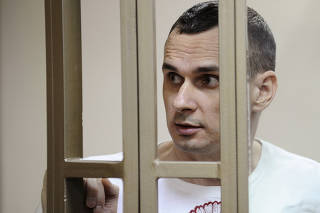 FILE PHOTO: Ukrainian film director Sentsov looks on from defendants' cage as he attends court hearing in Rostov-on-Don