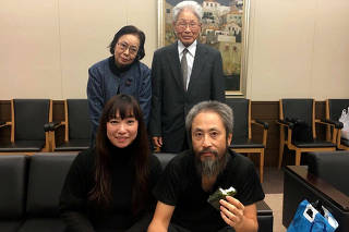 Freed Japanese journalist Yasuda poses with his wife Myu and parents after he met them at the airport in Narita