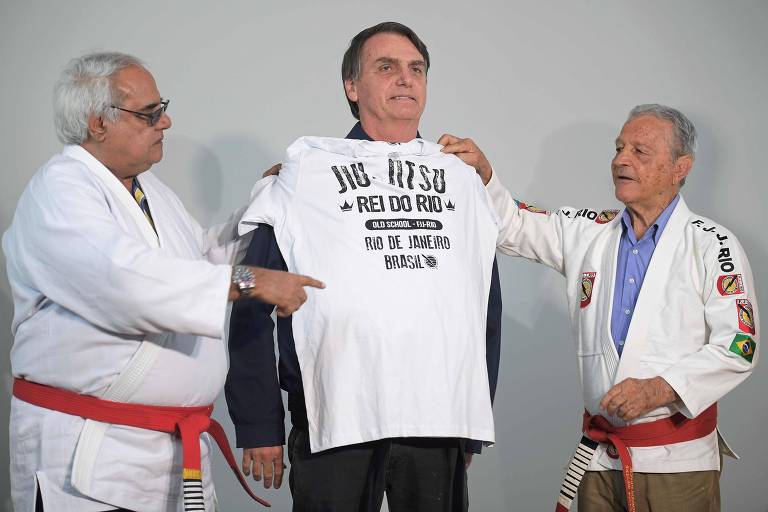 O candidato Jair Bolsonaro (PSL) recebe camiseta do lutador de jiu-jítsu Robson Gracie (esq.) no Rio de Janeiro