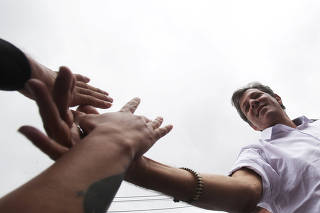 Fernando Haddad, presidential candidate of Brazil's leftist Workers Party (PT), shakes hands with his supporters during a march for peace at Heliopolis slum in Sao Paulo