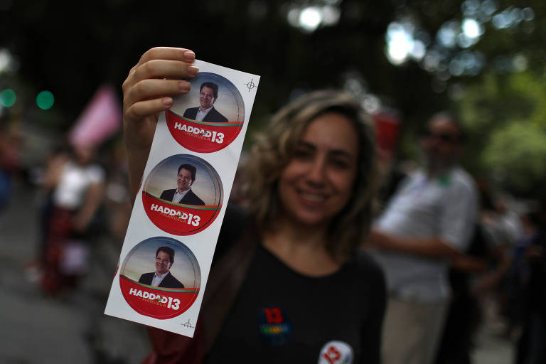 Apoiadora do candidato à Presidência Fernando Haddad (PT) mostra adesivo de campanha durante manifestação no Rio de Janeiro 