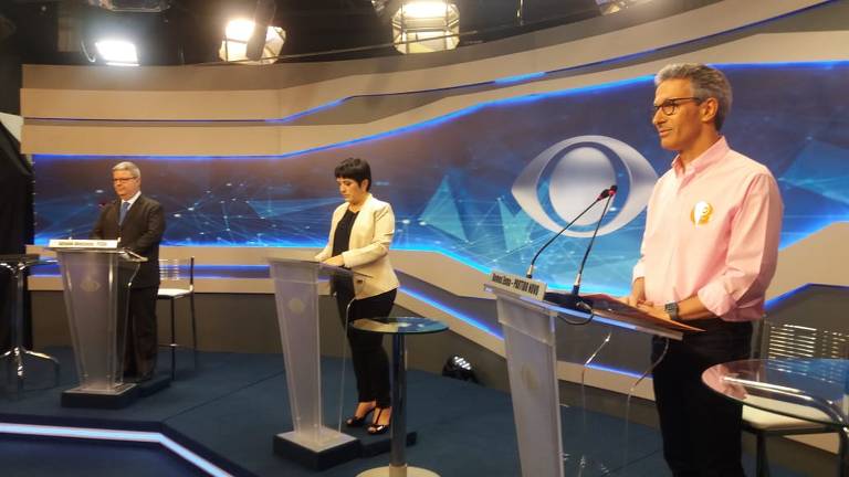 Romeu Zema (Novo) à frente e Antonio Anastasia (PSDB) ao fundo, posicionados para debate da Rede Bandeirantes para o governo de Minas Gerais